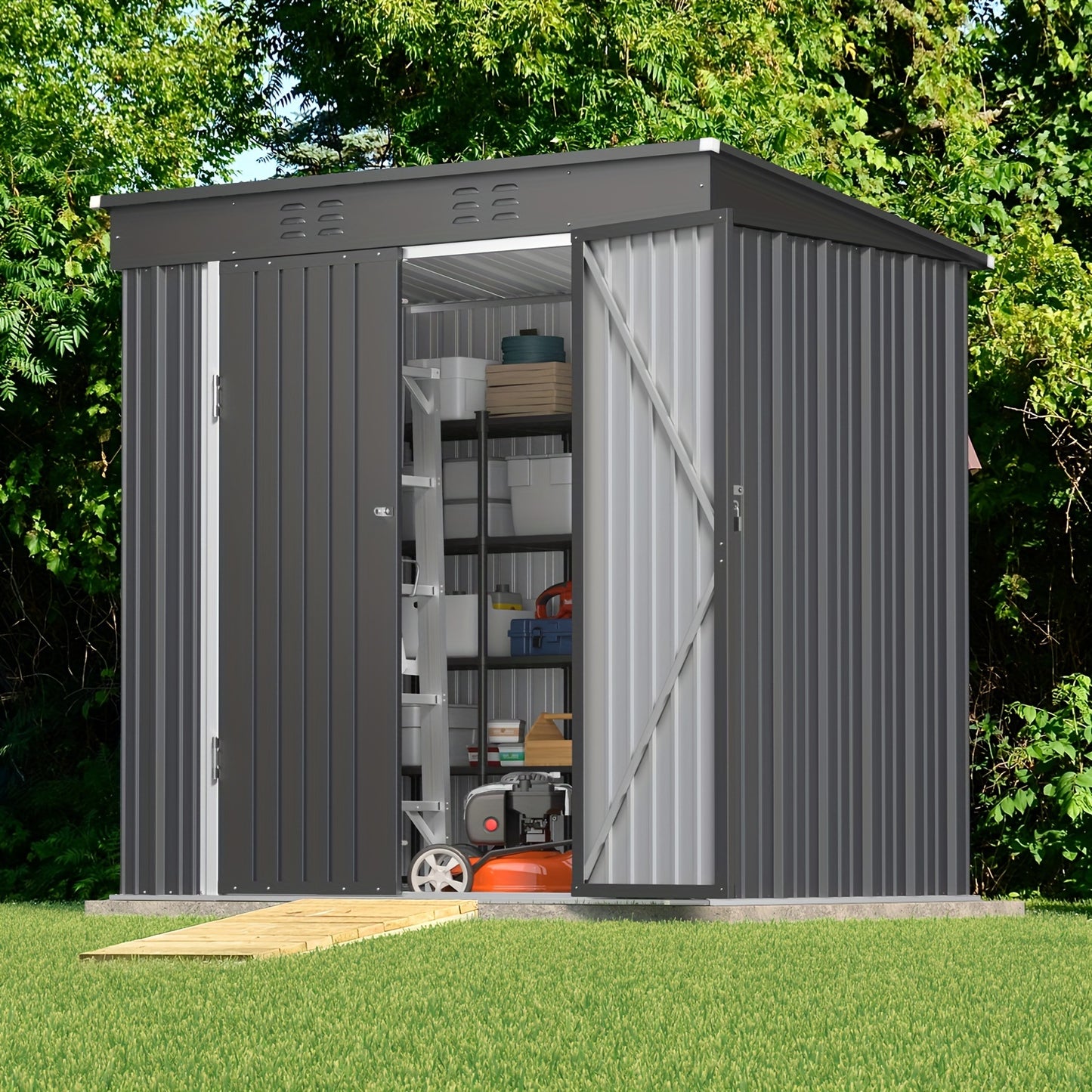 Gray metal storage shed with open door on a grassy area with trees in the background